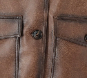 Detailopname van het bruine PU-lederen jack met knopen en afwerking van de zak