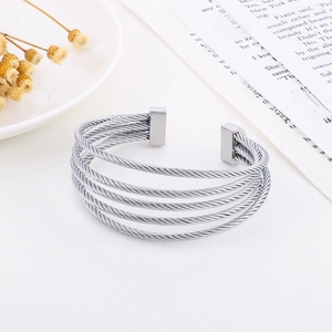 Detail of silver multi-layer stainless steel twisted cable cuff bracelet on white background