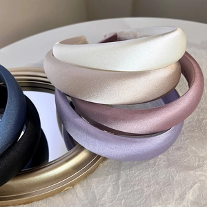 Close-up of padded satin headbands in multiple elegant colors with silky texture