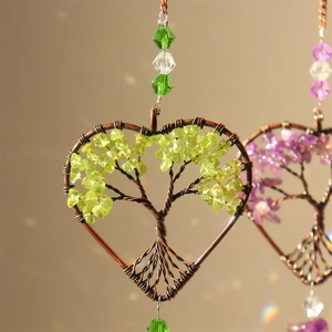 Macro detail of handmade heart-shaped Tree of Life crystal suncatcher with green beads