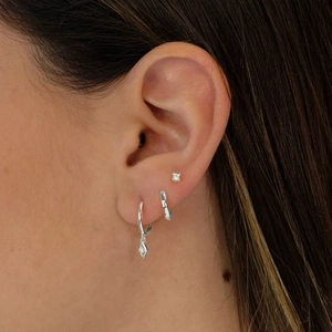 Close-up of 925 sterling silver earring set with diamond studs and hoop charms on model