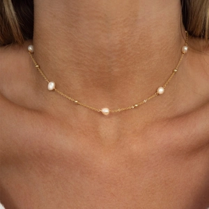 Elegante catena a serpente in acciaio placcato oro 18k con perle sul collo di una modella