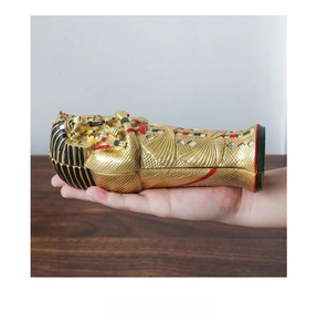 Detailed view of hand-held gold Egyptian pharaoh sarcophagus resin ornament and craft