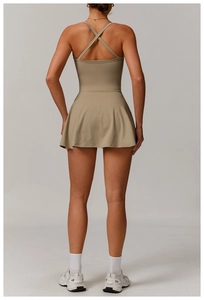 Detail of cross-back straps and pleated hem on olive green athletic tennis dress