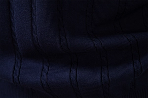 Nahaufnahme der dunkelblauen Strickweste mit Zopfmusterstruktur und hochwertigen Wollfasern