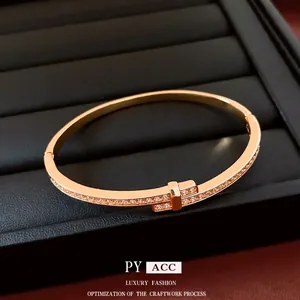 18K gold-plated hinged bracelet featuring T-shaped cross design with pave-set zircons