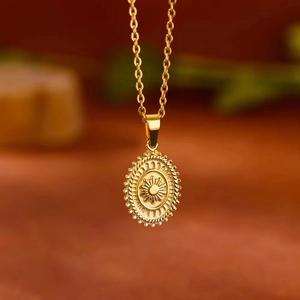 Vintage gold sunburst oval pendant necklace with a detailed twisted rope border