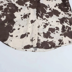 Gros plan détaillé de l'ourlet incurvé et des coutures sur chemise imprimé vache