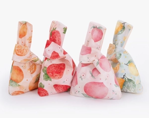 Detail of four velvet knot wrist bags featuring watercolor orange, strawberry and peach prints