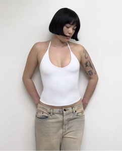 Detail of white halter neck top showing stretchy fabric and backless design on model