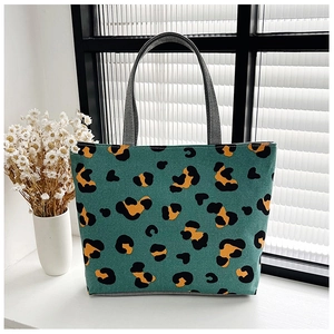 Detail of teal leopard print canvas tote bag on a windowsill with white flowers