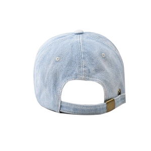 Close-up of adjustable metal buckle and washed denim texture on blue NYC baseball cap