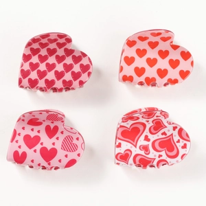 Set of four heart-shaped hair claws in red and pink patterns on white background