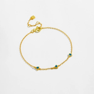 Elegant gold S925 silver bracelet featuring three blue triangular zircon charms on white base
