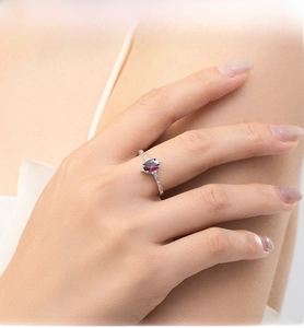 Macro detail of oval ruby red gemstone ring set in sterling silver on model hand