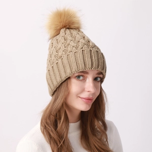 Winter khaki knit beanie featuring a diamond texture and large fluffy faux fur pom-pom