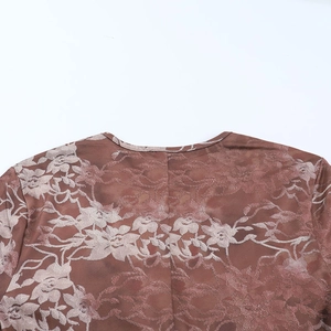 Close-up of the intricate brown floral lace embroidery and neckline stitching on the romper