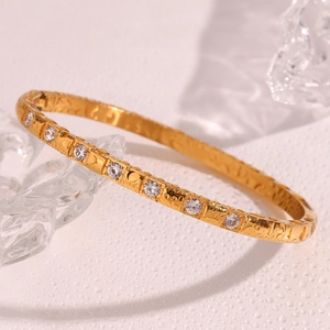 Macro detail of 18K gold plated bracelet with pave cubic zirconia and water droplets