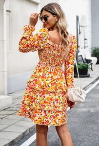 Detail of floral dress with square neckline and ruffled hem in yellow and red tones