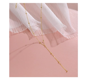 Detail view of a gold S925 sterling silver tassel Y-necklace with delicate metal beads