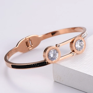 Detail of rose gold bangle with Roman numerals, white zircon stones and black diamonds