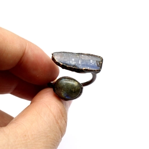 Macro view of vintage copper ring with raw blue kyanite and dark stone on hand