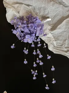Detailed view of handmade purple silk lily of the valley hair clip with pearl tassels