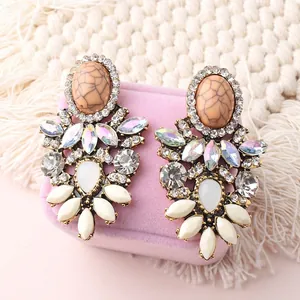 Macro shot of boho flower earrings with crystals on a pink velvet jewelry box display