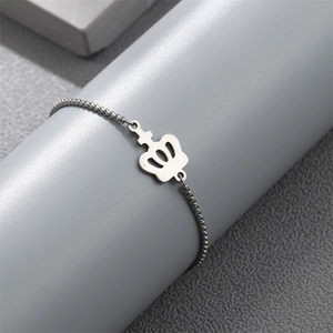 Macro shot of a silver crown pendant on a box chain wrapped around a jewelry display