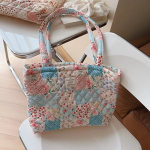 Detail of floral quilted cotton tote bag with vintage patchwork and woven brand tag