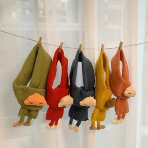 Cozy knitted baby scarves with cute cartoon animal decor hanging on a laundry line