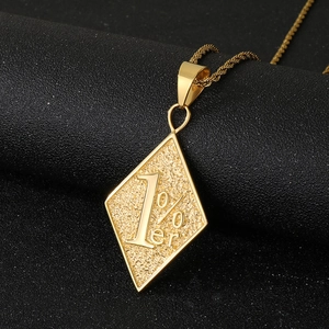Détail macro du pendentif losange doré avec gravure 1% er sur texture noire