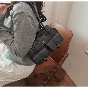 Detail showing vintage retro grey leather bag with dual buckled pockets and metal logo