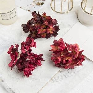 Elegant vintage burgundy faux hydrangea flowers on lace fabric with decorative props