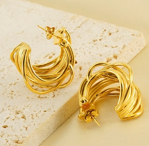 Close-up of chunky 18K gold plated multi-layer C-shape hoop earrings on a stone surface