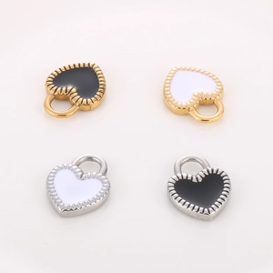 Detailed macro view of four stainless steel heart pendants with black and white enamel finish