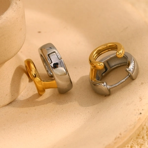 Dettaglio degli orecchini geometrici a doppio strato in finitura oro e argento