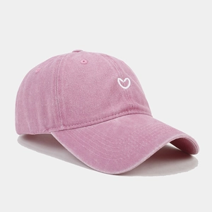 Close-up of heart embroidery detail on pink washed cotton baseball cap with retro style