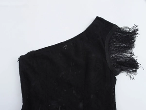 Close-up of black lace shoulder detail featuring elegant fringes and fine fabric texture