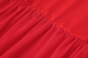 Close-up of elegant red fashion dress showing plain fabric and fine mesh texture