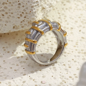 Macro view of two-tone braided geometric ring with gold ridges and silver texture