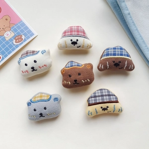 Detailed view of six cute embroidered animal plush heads with colorful plaid hats