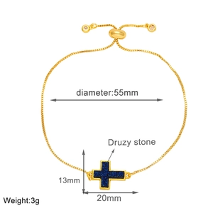 Detail of adjustable gold-plated chain bracelet with blue druzy stone cross pendant