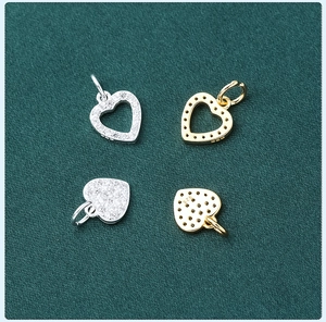 Detailed macro view of S925 sterling silver heart charms with pavé cubic zirconia inlay