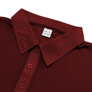 Detail of burgundy waffle knit polo shirt showing three-button placket and fabric texture