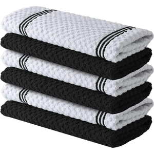 Detail of stacked black and white waffle weave cotton kitchen towels with stripe edging