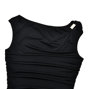 Detail of black one-shoulder dress featuring golden buckle and pleated fabric texture