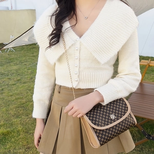 Mannequin portant un cardigan beige et un sac bandoulière vintage marron avec chaîne