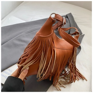 Detail shot of brown lychee-patterned leather shoulder bag with multi-layer tassel trim