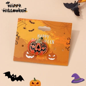 Detailed view of Halloween pumpkin brooch with orange rhinestones on festive display card